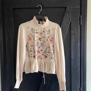 Cream blouse with flowers.